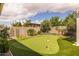 Landscaped backyard features a putting green, mature trees, and a serene outdoor space at 22670 E Russet Rd, Queen Creek, AZ 85142