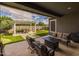 Covered patio features ample seating space, an outdoor kitchen, and a view of the landscaped backyard at 22670 E Russet Rd, Queen Creek, AZ 85142