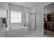 Bright bathroom with white marble tile, soaking tub, glass shower and access to walk-in closet at 22670 E Russet Rd, Queen Creek, AZ 85142