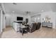 Bright living room featuring wood-look tile flooring, comfortable seating, and large television for entertainment at 22670 E Russet Rd, Queen Creek, AZ 85142