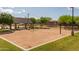 Outdoor community sand volleyball court with covered seating area and manicured green spaces on a bright sunny day at 22670 E Russet Rd, Queen Creek, AZ 85142