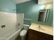 Bathroom featuring a tiled bathtub, toilet, and sink with oak vanity at 2328 W Lupine Ave, Phoenix, AZ 85029