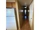 Hallway with tile floor, recessed lighting, and white walls leading to a kitchen with white refrigerator at 2328 W Lupine Ave, Phoenix, AZ 85029