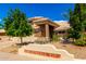 Inviting home exterior with a well-manicured front yard, mature trees, and colorful flowerbeds at 23829 N 59Th Dr, Glendale, AZ 85310