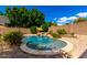Charming pool with a small rock waterfall feature, surrounded by desert landscaping and stone pavers at 23829 N 59Th Dr, Glendale, AZ 85310
