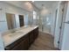 Bathroom featuring double sinks, granite countertop, and separate glass door shower at 25351 W Bowker St, Buckeye, AZ 85326