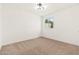 A bright bedroom with plush carpet, a modern light fixture, and a window providing natural light at 2625 W Ocotillo Rd # 4, Phoenix, AZ 85017
