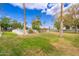 Expansive grassy area leading to a fenced community pool under a bright blue sky with palm trees at 2625 W Ocotillo Rd # 4, Phoenix, AZ 85017