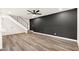 Modern living room with a striking black accent wall, light wood-look floors, and stairs to the upper level at 2625 W Ocotillo Rd # 4, Phoenix, AZ 85017