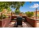 Outdoor BBQ area with grill, lush greenery, and community pool in the background at 3031 N Civic Center Plz # 340, Scottsdale, AZ 85251