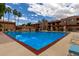 Beautiful pool surrounded by palm trees, lounge seating, and well-maintained community buildings under a partly cloudy sky at 3031 N Civic Center Plz # 340, Scottsdale, AZ 85251