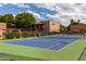 Well-maintained tennis court with a vibrant blue surface, nestled within the community grounds under a partly cloudy sky at 3031 N Civic Center Plz # 340, Scottsdale, AZ 85251