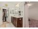 Bathroom features dual sink vanity, tile floors, and large mirror with closet acces at 3080 E Palmdale Ln, Gilbert, AZ 85298