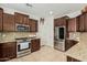 A modern kitchen features stainless steel appliances, granite countertops, and dark wood cabinets at 3080 E Palmdale Ln, Gilbert, AZ 85298