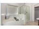 Bright bathroom with a soaking tub, a glass-enclosed shower, and neutral tile flooring at 3080 E Palmdale Ln, Gilbert, AZ 85298