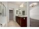 Beautiful main bathroom with double sink vanity, large mirrors, and walk-in closet access at 3080 E Palmdale Ln, Gilbert, AZ 85298