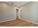 Bedroom with pristine hardwood floors, neutral walls, and access to another room through a white door at 3171 S Hawthorn Ct, Gold Canyon, AZ 85118