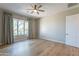 Spacious bedroom with hardwood floors, ceiling fan, large window with curtains, and neutral wall paint at 3171 S Hawthorn Ct, Gold Canyon, AZ 85118