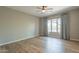 Bright, airy bedroom with large window, neutral walls, hardwood floors, and contemporary ceiling fan at 3171 S Hawthorn Ct, Gold Canyon, AZ 85118