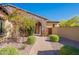 Front entryway with stone arch, flowering tree, desert landscaping, and brick walkway at 3171 S Hawthorn Ct, Gold Canyon, AZ 85118