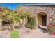 Front exterior of home with stone archway, flowering tree and manicured bushes at 3171 S Hawthorn Ct, Gold Canyon, AZ 85118