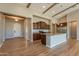 Expansive open-concept kitchen with hardwood floors, a central island, stainless fridge, and wooden beam architecture at 3171 S Hawthorn Ct, Gold Canyon, AZ 85118