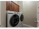 Laundry room featuring front load washer and dryer with upper cabinets at 3171 S Hawthorn Ct, Gold Canyon, AZ 85118