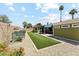 Fenced backyard with artificial grass, desert landscaping, and a covered patio with an outdoor seating area at 4008 W Citrus Way, Phoenix, AZ 85019