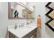 Modern bathroom features a light countertop, gray vanity, and decorative mirror at 4008 W Citrus Way, Phoenix, AZ 85019