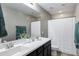 Bathroom with a double sink vanity, large mirror, and a shower with white curtain at 41311 W Elm Dr, Maricopa, AZ 85138