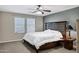 Cozy bedroom featuring a large bed, window with blinds, carpet, and ceiling fan at 41311 W Elm Dr, Maricopa, AZ 85138