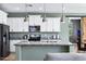 Modern kitchen with granite countertops, stainless steel appliances, and white cabinetry for a sleek and functional space at 41311 W Elm Dr, Maricopa, AZ 85138