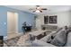Cozy living room featuring blue accent wall, unique decor, gray sofa with pillows, and patterned rug at 41311 W Elm Dr, Maricopa, AZ 85138