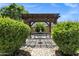 Wood pergola in a charming backyard with plenty of greenery at 41311 W Elm Dr, Maricopa, AZ 85138