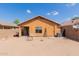 View of the home's backyard featuring a dirt yard and small patio at 41373 W Coltin Way, Maricopa, AZ 85138