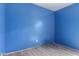 Empty bedroom with blue painted walls and wood-look flooring at 41373 W Coltin Way, Maricopa, AZ 85138