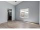 A clean bedroom with a large window and wood-look laminate flooring at 41373 W Coltin Way, Maricopa, AZ 85138