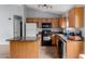 This home features a kitchen with granite counters, wood cabinets and black appliances at 41373 W Coltin Way, Maricopa, AZ 85138