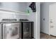 Laundry room with modern washer and dryer units and storage shelf at 41373 W Coltin Way, Maricopa, AZ 85138