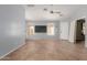 Open living room with tile floors, ceiling fan, and plenty of natural light at 41373 W Coltin Way, Maricopa, AZ 85138
