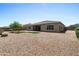A backyard featuring a gravel landscape, a touch of artificial turf, and a well-maintained exterior wall at 4671 N 185Th Ln, Goodyear, AZ 85395