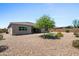 Backyard featuring a gravel landscape, a small patch of artificial turf, and a tree providing shade and greenery at 4671 N 185Th Ln, Goodyear, AZ 85395