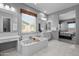 Stylish bathroom with a soaking tub, dual vanities, and wood-framed mirrors providing a spa-like experience at 4671 N 185Th Ln, Goodyear, AZ 85395