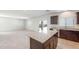 Modern kitchen with granite countertops and center island, seamlessly connecting to a bright and airy living space at 5041 S 252Nd Ave, Buckeye, AZ 85326