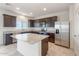 Bright kitchen with dark wood cabinets, granite countertops, stainless steel appliances, and a convenient center island at 5041 S 252Nd Ave, Buckeye, AZ 85326