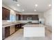 Bright kitchen boasts dark wood cabinets, granite countertops, stainless steel appliances, and a center island at 5041 S 252Nd Ave, Buckeye, AZ 85326