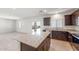 Modern kitchen boasts granite countertops and a center island, flowing into a bright, open living space at 5041 S 252Nd Ave, Buckeye, AZ 85326