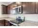 Close-up shot of kitchen with granite countertops, stainless steel microwave, and a sleek black cooktop at 5041 S 252Nd Ave, Buckeye, AZ 85326