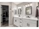 Dual vanity bathroom featuring white cabinets, granite countertops, modern sinks, and walk-in closet at 5754 W Larkspur Dr, Glendale, AZ 85304