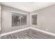 Neutral bedroom with light gray walls, white trim, blinds on the windows, and wood-look tile floor at 5754 W Larkspur Dr, Glendale, AZ 85304